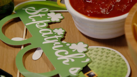 Close-Up-Of-Irish-Novelties-And-Props-With-Snacks-Of-Tortilla-Chips-And-Salsa-At-St-Patrick's-Day-Party